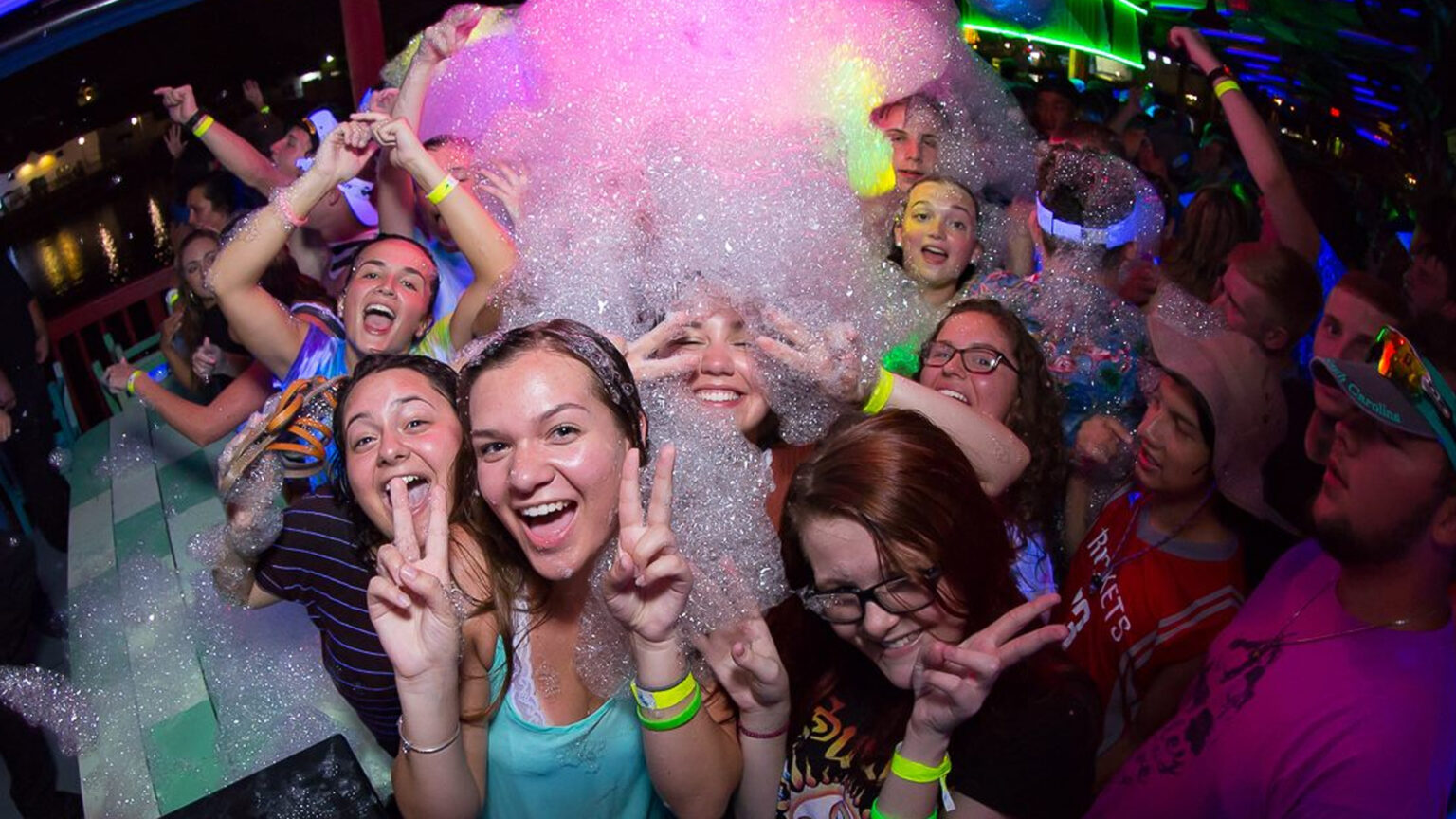 Grads cheering under a wave of foam at a Myrtle Beach Senior Week foam party