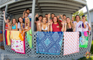 Senior Week group on a porch with beach towels in North Myrtle Beach