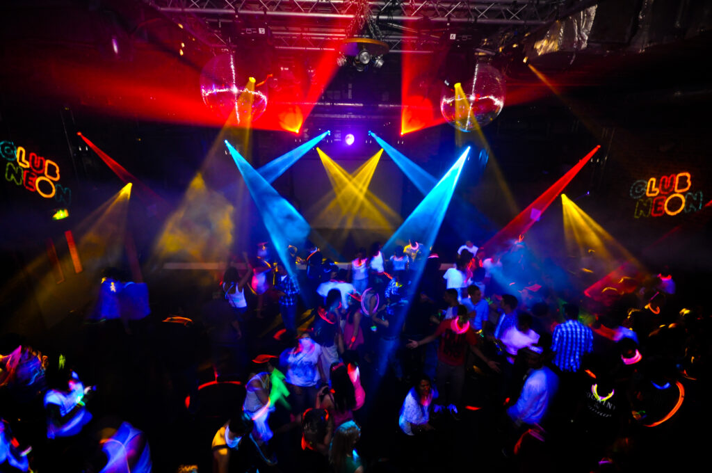 Dance floor lit by colorful laser and spot lights at a Senior Week party
