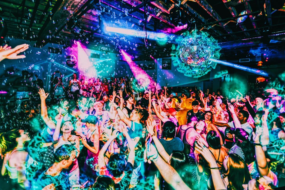 Grads dancing under disco balls and confetti at a Senior Week party