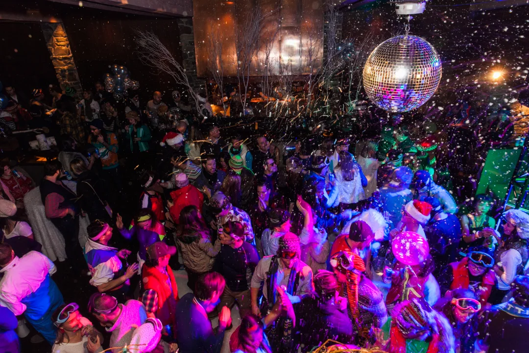 Crowd dancing under a mirror ball at a Senior Week theme party