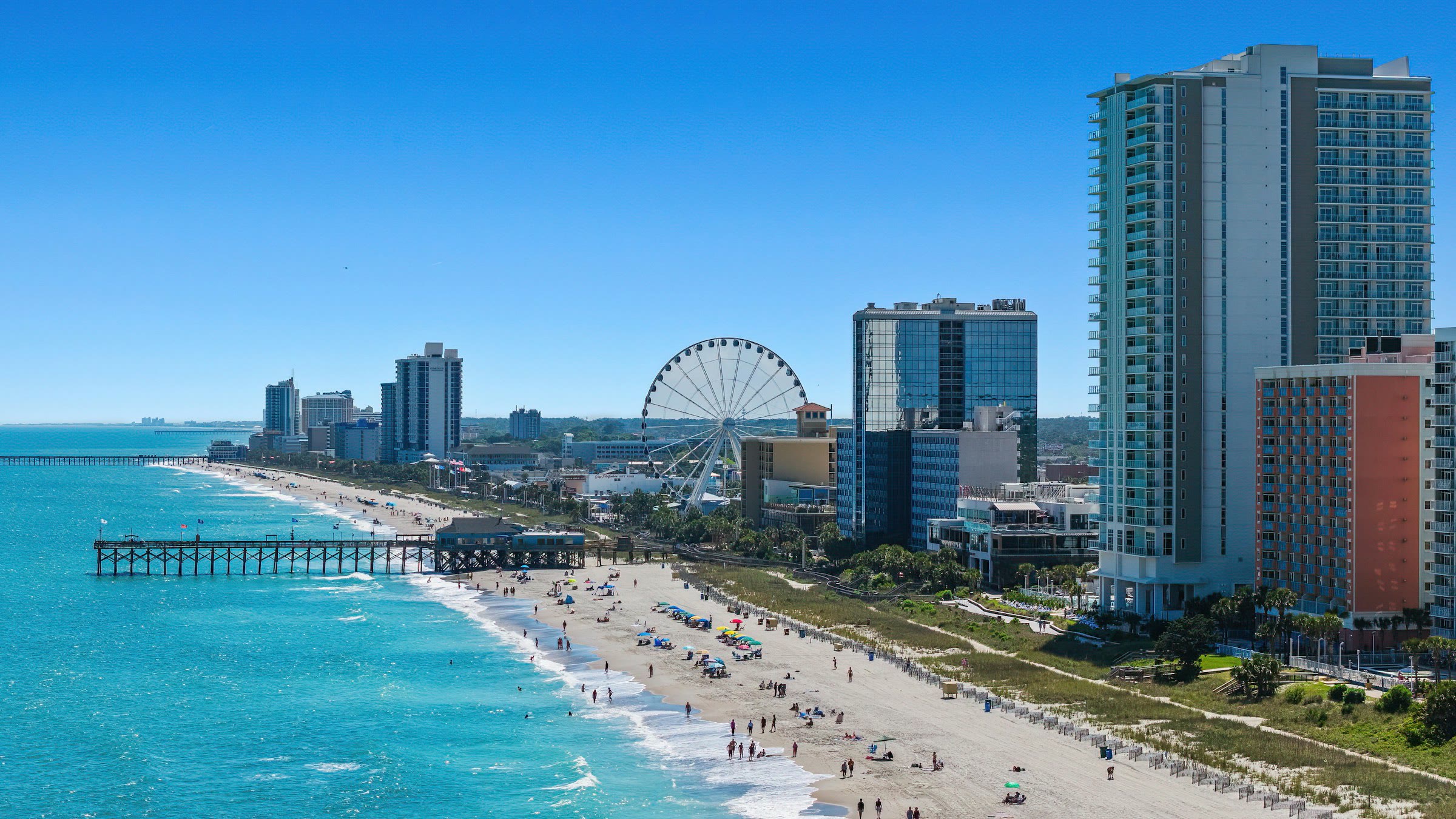 Aerial view of the Myrtle Beach oceanfront with the SkyWheel, pier and hotels on a sunny day