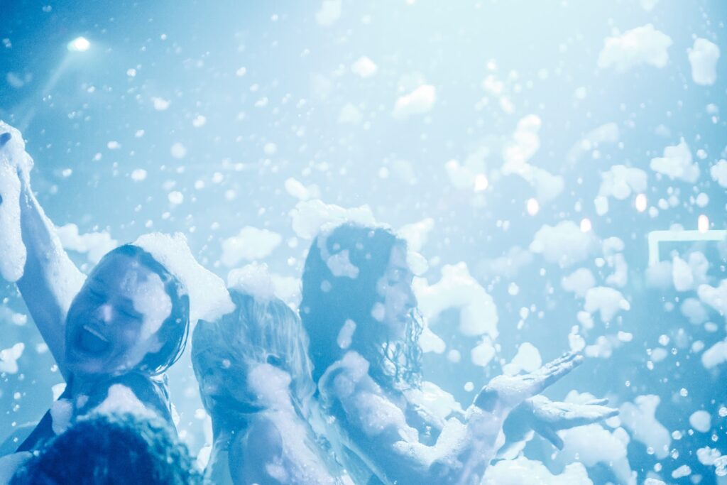 Friends dancing in clouds of foam at a Myrtle Beach Senior Week foam party